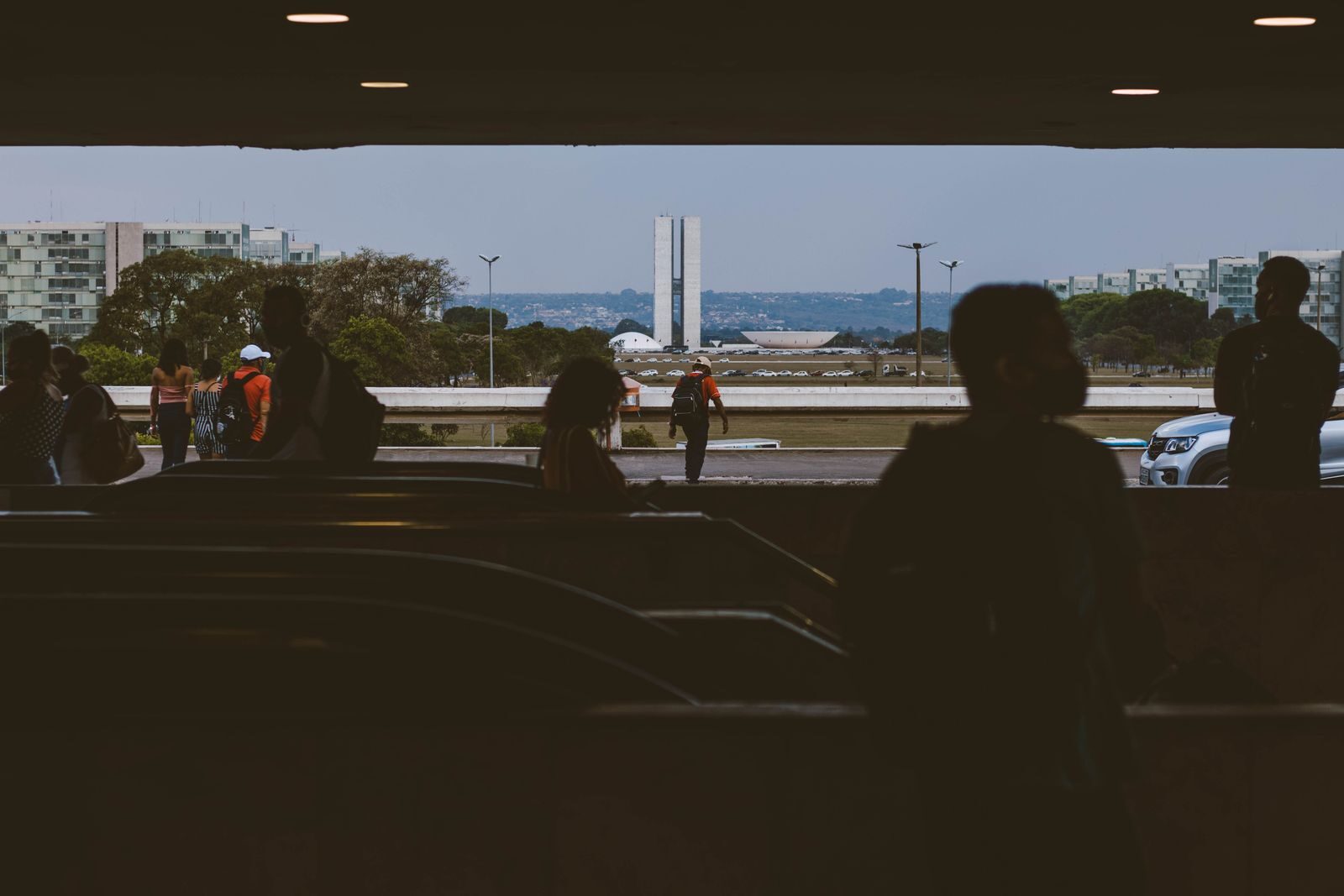 Silhuetas de pessoas em passagem subterrânea em Brasília