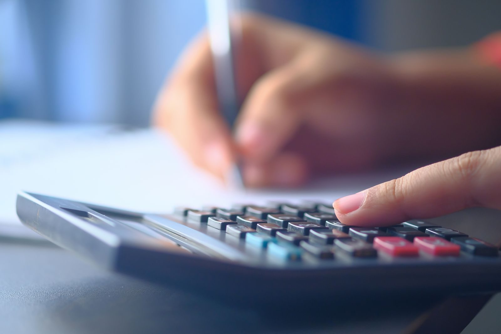 Calculadora e cédulas de real sobre uma mesa
