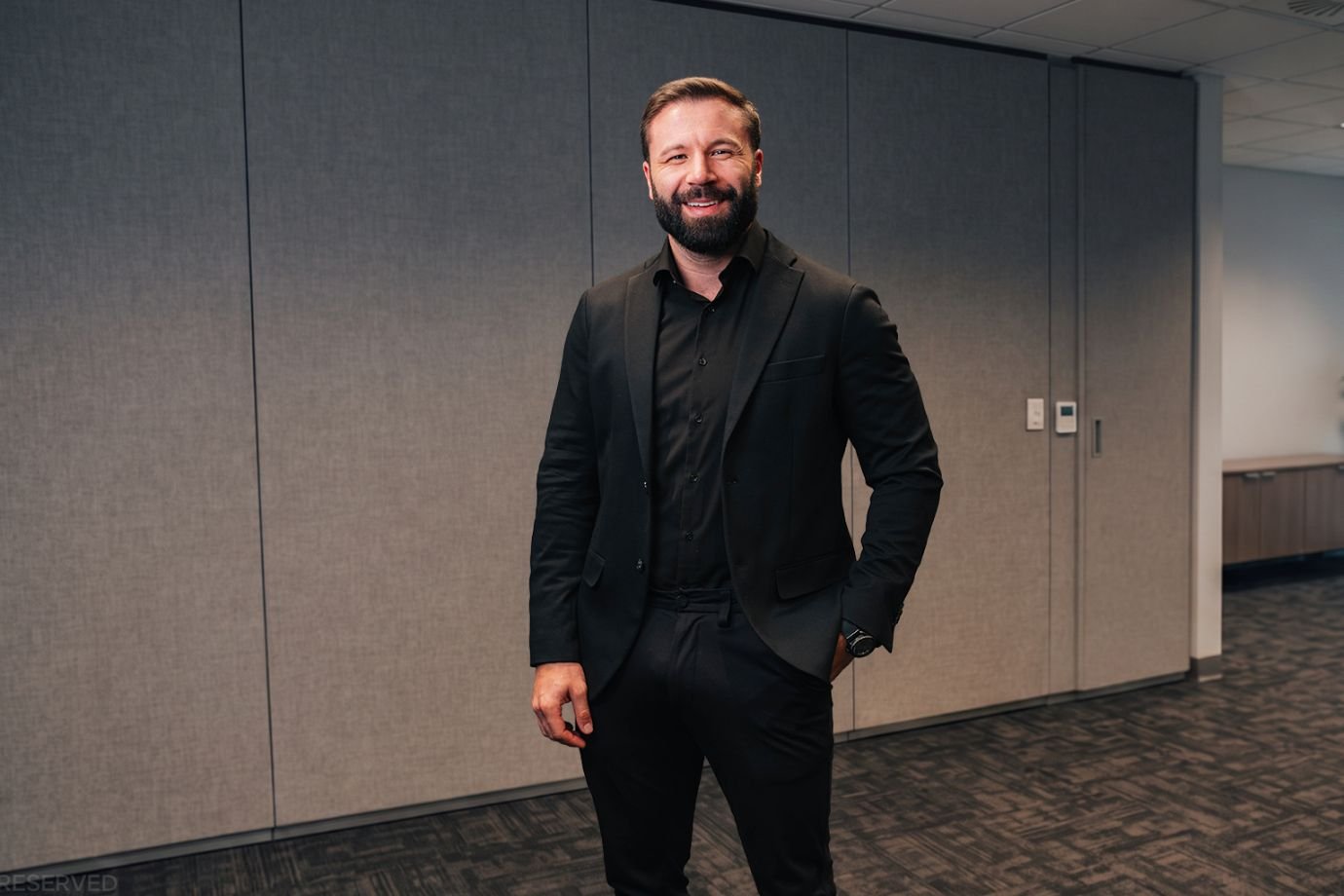 Kleber Amora, CEO e fundador da Berry, de paletó preto, em retrato de divulgação no escritório