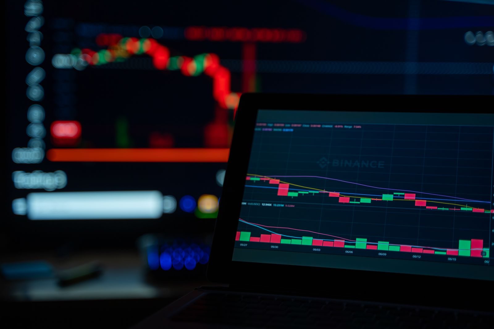 Tela de computador com símbolos de criptomoedas e código em ambiente escuro