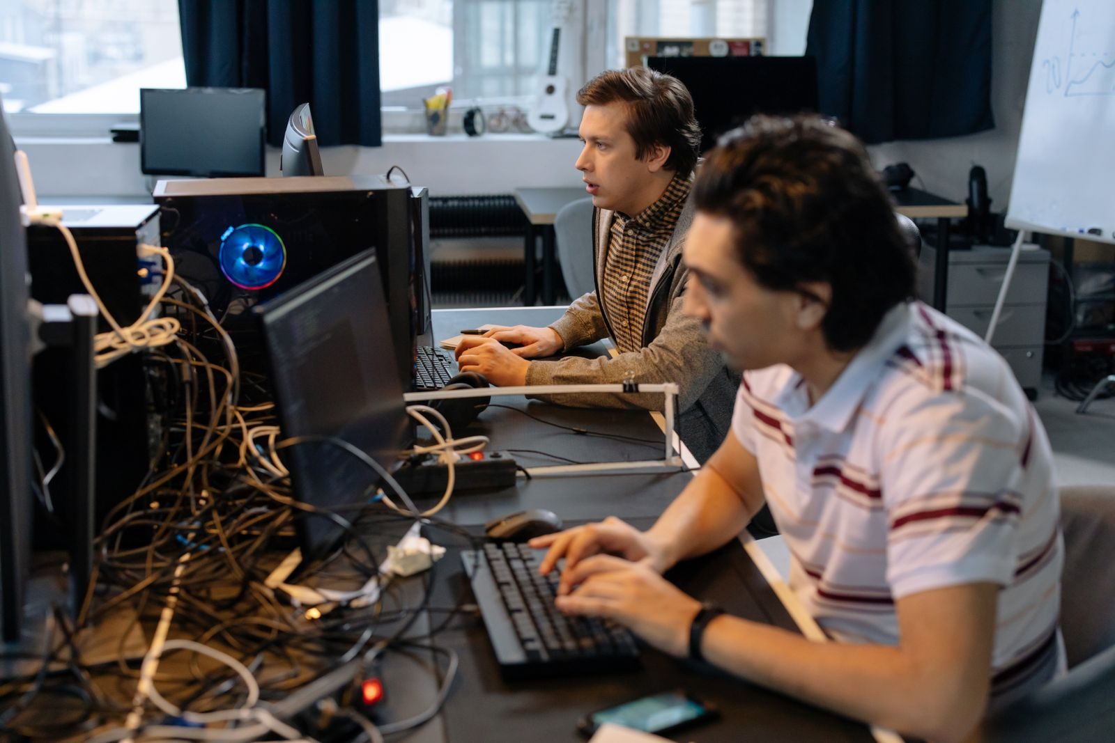 Trabalhadores em um escritório diante de computadores