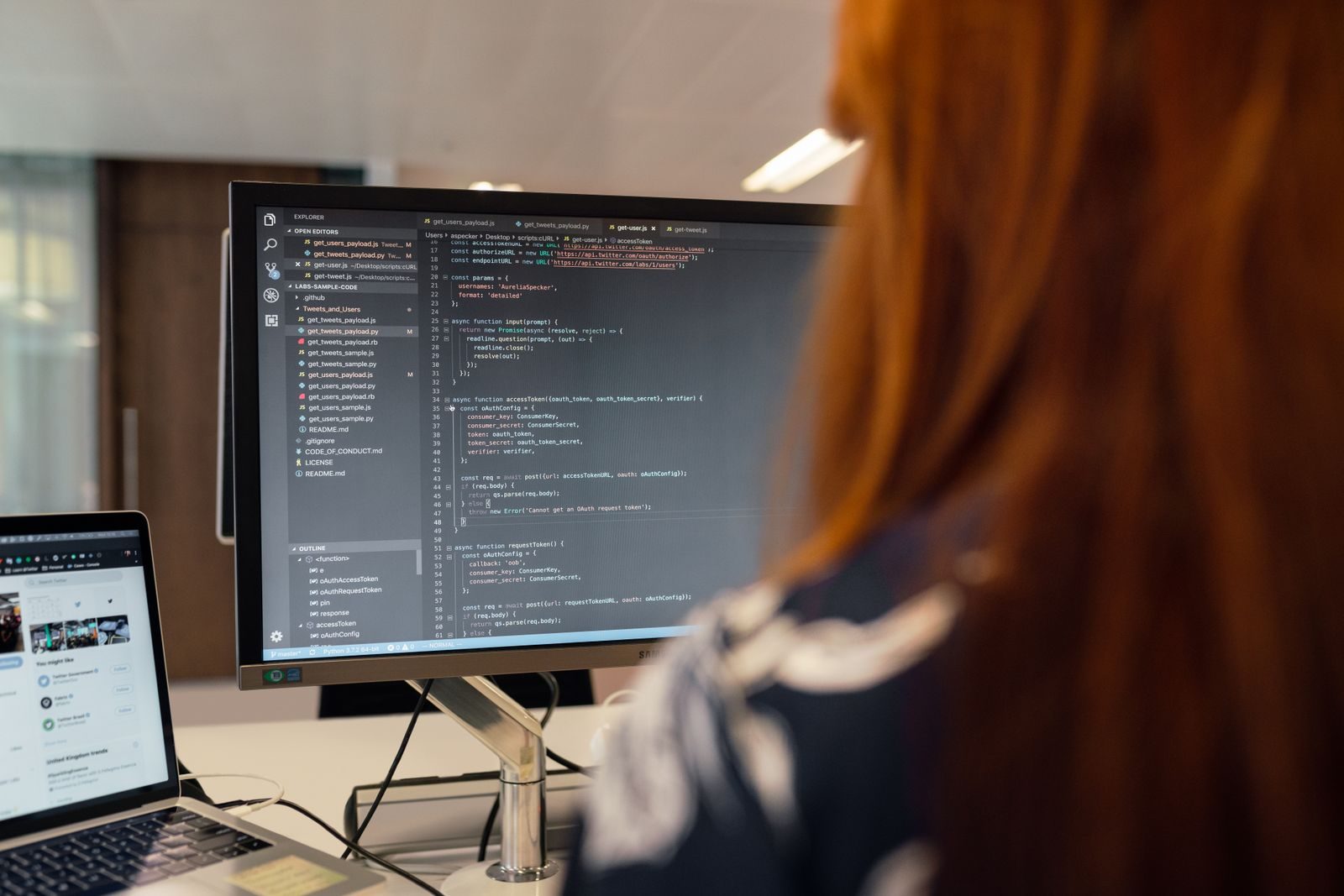 Programador trabalhando em código diante de monitores