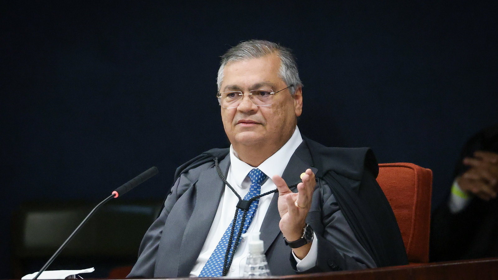 Flávio Dino, ministro do STF, de toga, fala ao microfone no plenário da Corte