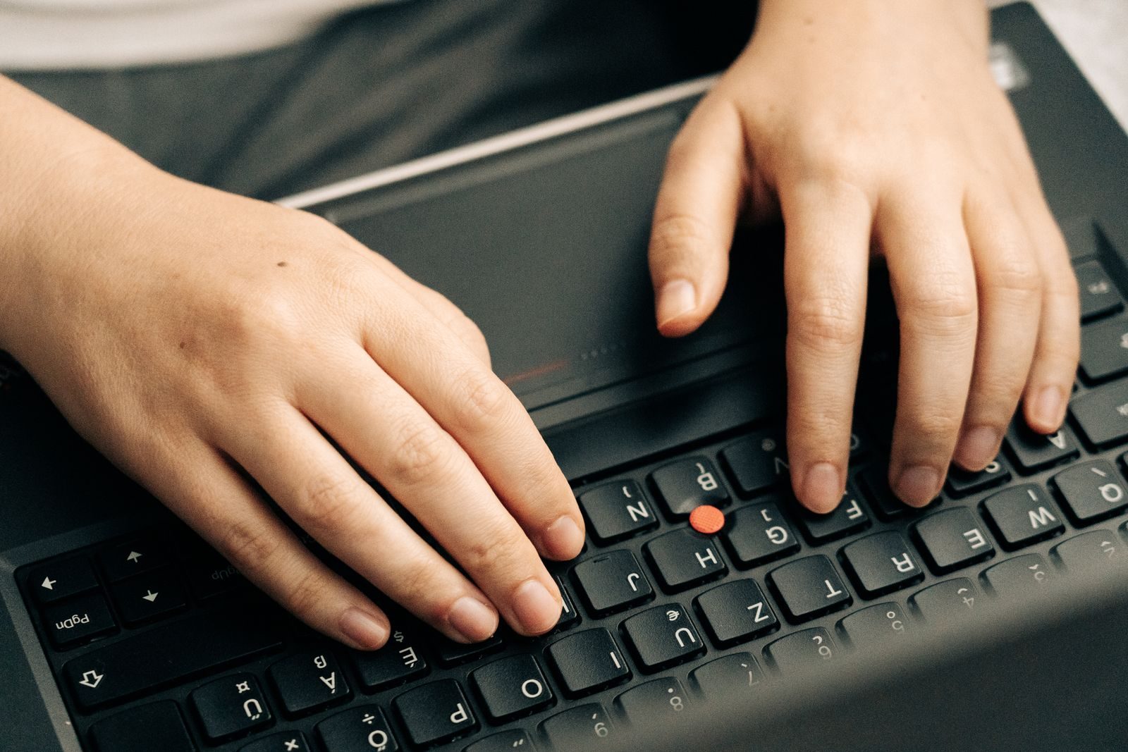 Profissional digitando em notebook em ambiente de escritório