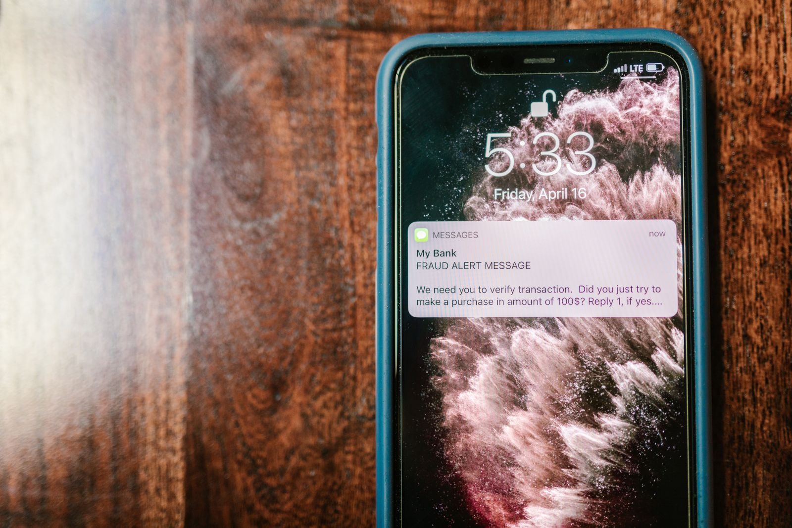 Mão segurando smartphone com alerta de segurança digital