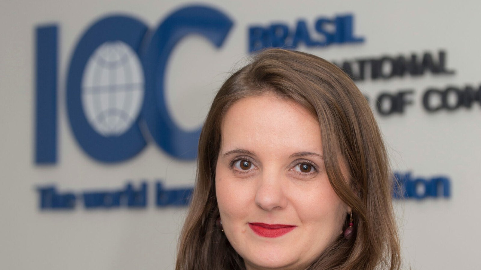 Gabriella Dorlhiac, diretora-executiva da ICC Brasil, de blazer preto em frente ao logo da entidade