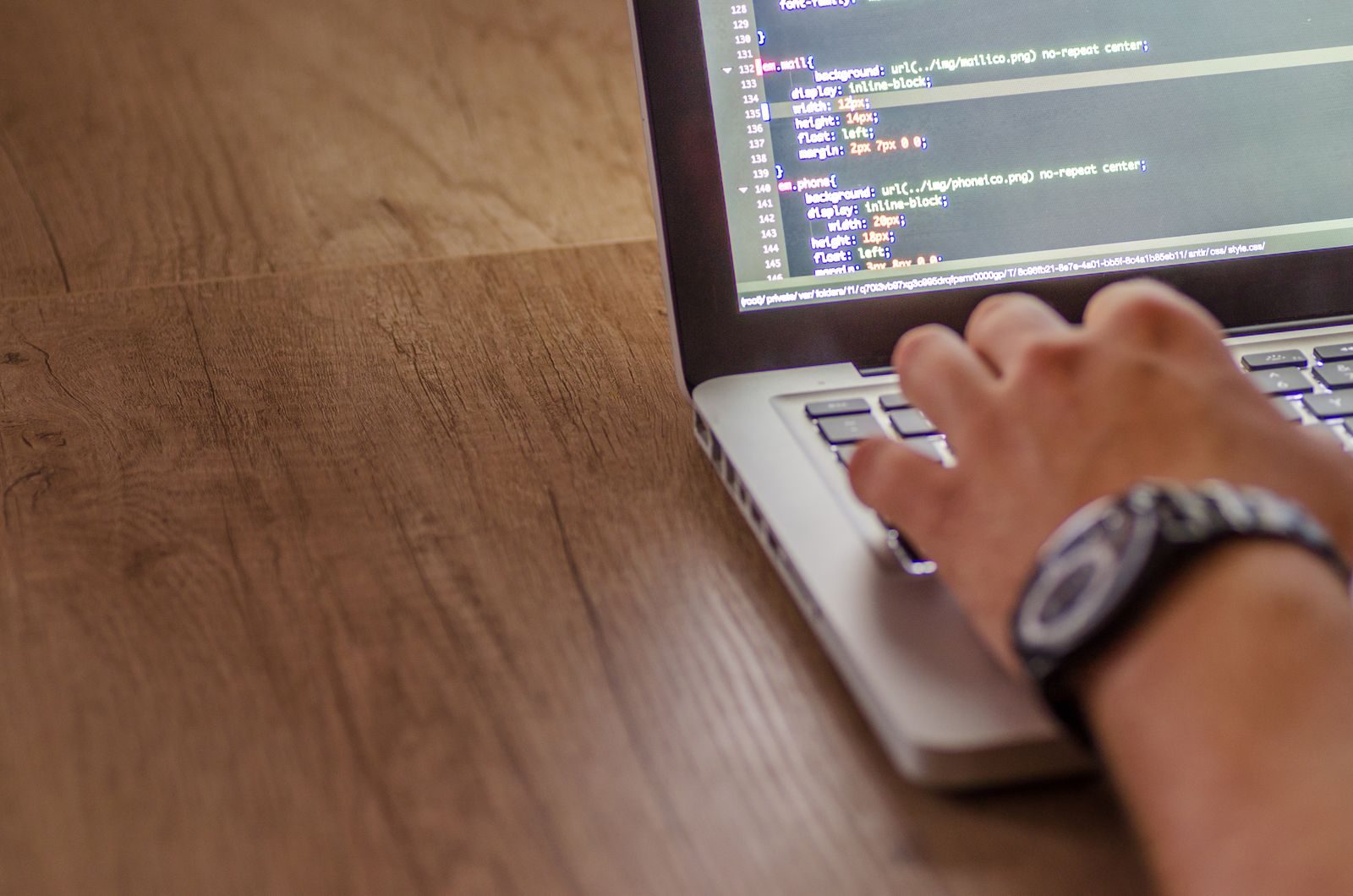 Profissional de tecnologia escrevendo código em um notebook