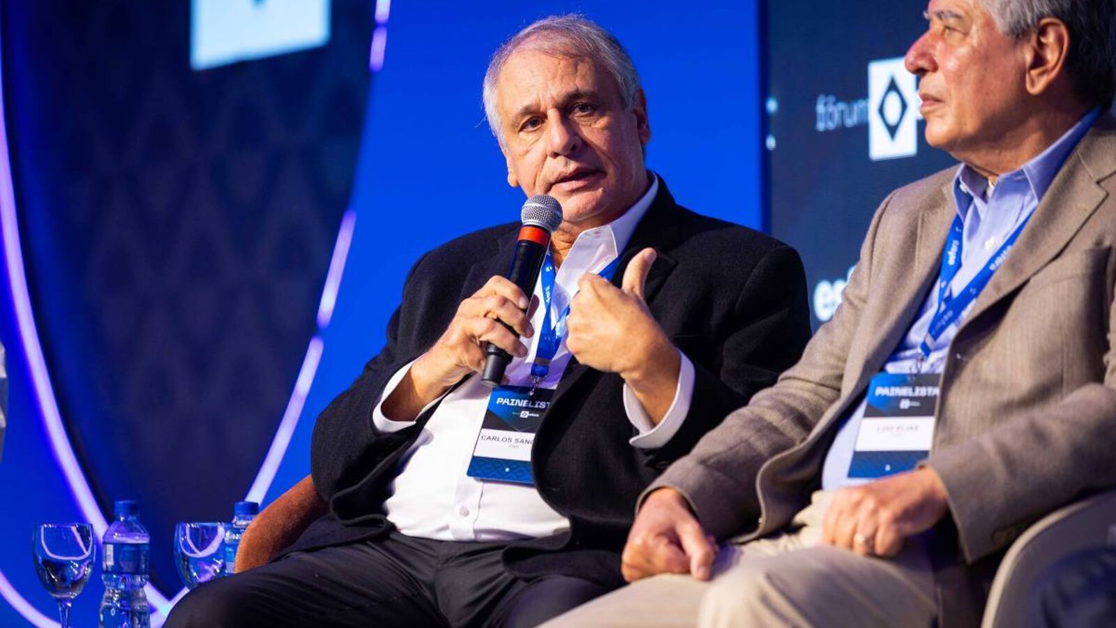 Carlos Sanchez, principal sócio do Grupo EMS, de terno escuro, fala ao microfone em evento
