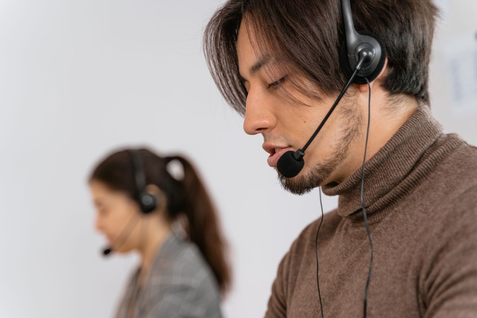 Atendentes em central de atendimento ao cliente com fones de ouvido