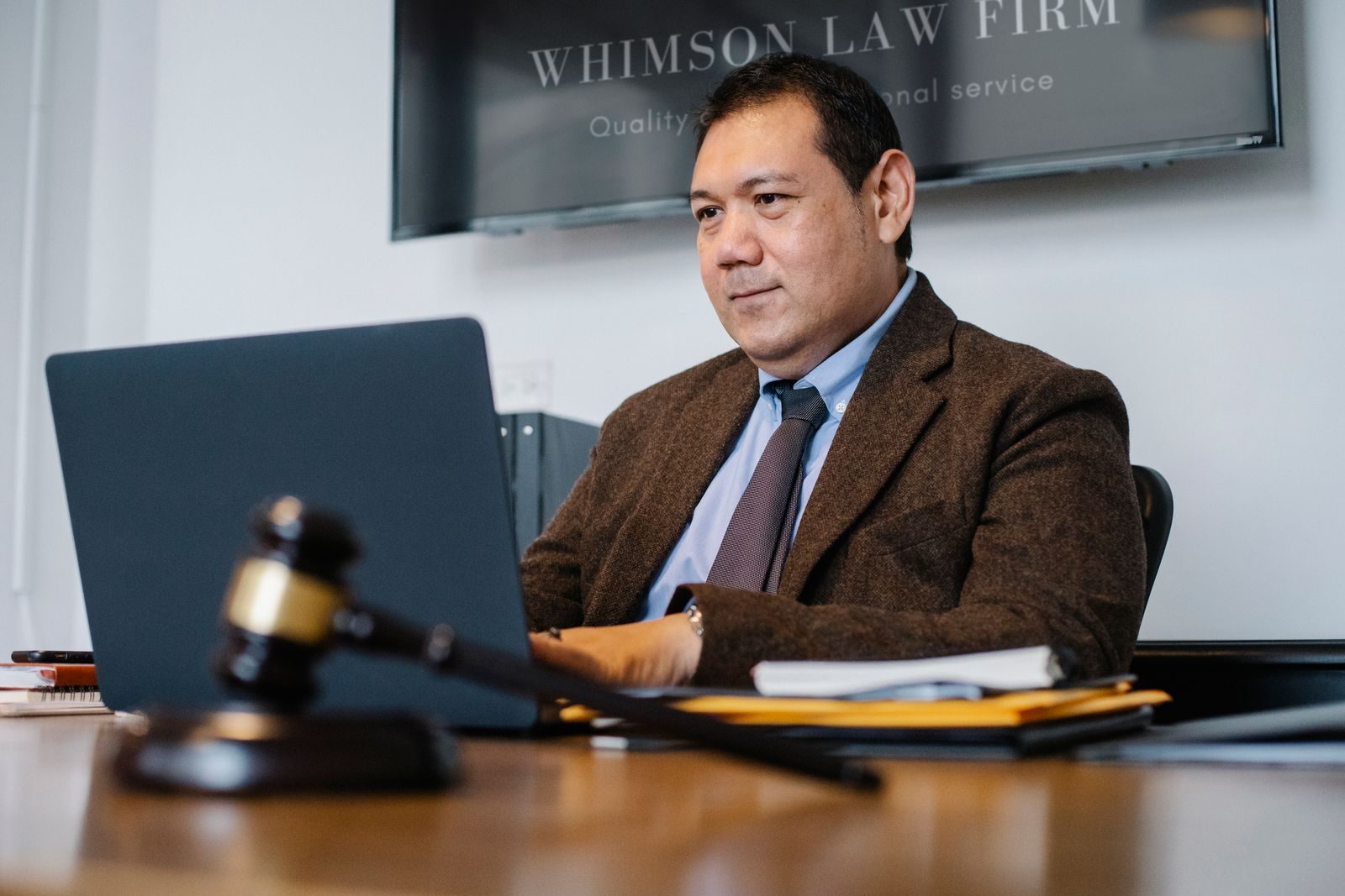 Martelo de juiz ao lado de um notebook em uma sala de tribunal